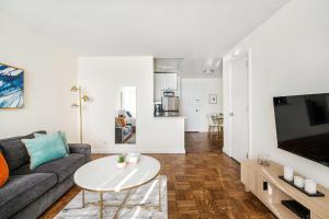 ニューヨークにあるLovely and Comfy Studio in NYCのソファとテーブルのあるリビングルーム +7枚の写真