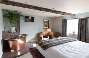 a bedroom with a large bed and a table and chairs at The Crown Hotel in Wells next the Sea