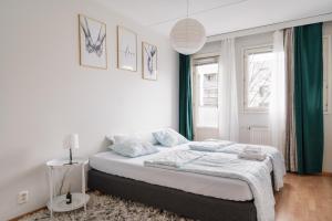 een witte slaapkamer met een bed en een raam bij Spacious City Retreat with Private Sauna in Helsinki