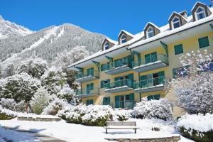 un edificio en la nieve con un banco delante en Résidence Jardins d'Androsace 17 - Happy Rentals, en Chamonix-Mont-Blanc