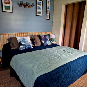 a bedroom with a bed with blue sheets and pillows at Cozy House with Terrace in Upper Prince's Quarter in Upper Prince's Quarter