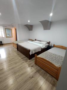 drie bedden in een kamer met houten vloeren bij Agroturystyka u podnóża Gór Sowich in Pieszyce