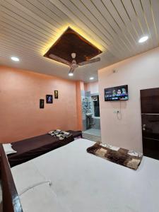 Una habitación con una cama y un televisor de pantalla plana. en Shri Mahaveer Residency, en Ayodhya
