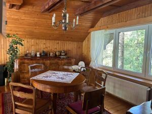 une salle à manger avec une table et des chaises et une fenêtre dans l'établissement Dom na Topolowej, à Ustroń