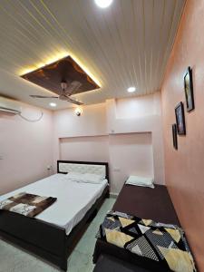2 camas en una habitación con techo en Shri Mahaveer Residency, en Ayodhya