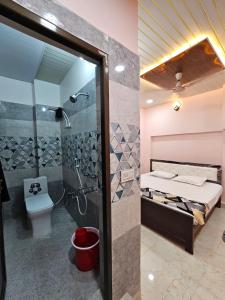 y baño con cama, ducha y aseo. en Shri Mahaveer Residency, en Ayodhya