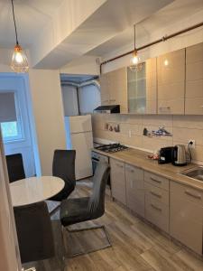 a kitchen with a table and chairs and a sink at illy apartament in Craiova