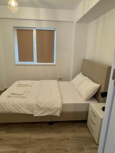 a small bedroom with a bed and a window at illy apartament in Craiova