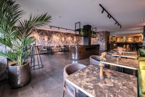 um restaurante com mesas e cadeiras e uma planta em Van der Valk Hotel Vianen - Utrecht em Vianen