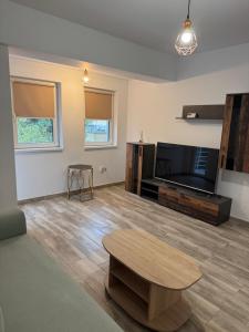a living room with a coffee table and a flat screen tv at illy apartament in Craiova