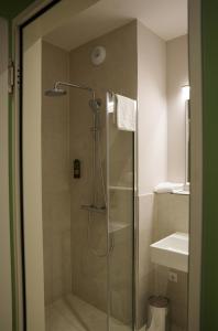 una ducha con puerta de cristal en un baño en qnorke Hotel, en Berlín