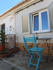 a blue chair and a table on a patio at Toca da raposa in Raposeira +22 photos