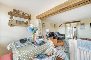 a living room with a table and a couch at Sunset View in Thornham