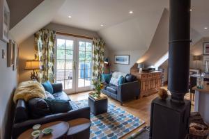 ein Wohnzimmer mit Couch und Ofen in der Unterkunft Beautiful dog friendly lodge with hot tub in Aboyne