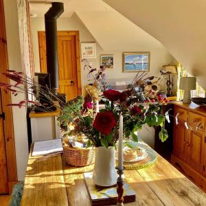 einen Tisch mit einer Blumenvase auf dem Tisch in der Unterkunft Beautiful dog friendly lodge with hot tub in Aboyne