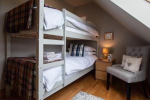 a bunk bed in a room with a bed and a chair at Tanar View in Aboyne
