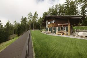 a house on a hill with a large grass yard at Chalet Magdalena und Lodges in Avelengo