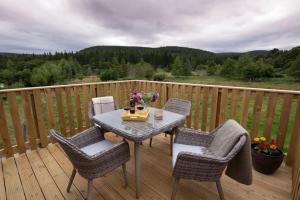 a wooden deck with a table and chairs on it at Tanar View in Aboyne