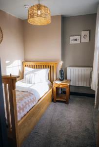 a bedroom with a bed and a table with a lamp at The Hideaway in Stratford-upon-Avon