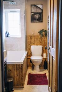 a bathroom with a toilet and a tub and a sink at The Hideaway in Stratford-upon-Avon