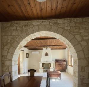 an archway in a room with a table and a fireplace at Horizon Giouchtas View Archanes Home in Archanes +35 photos