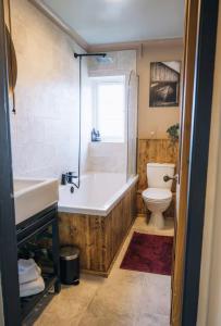 a bathroom with a tub and a toilet and a sink at The Hideaway in Stratford-upon-Avon