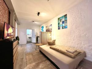 a living room with a bed and a wall at Industrial feeling in a quiet location in Leipzig