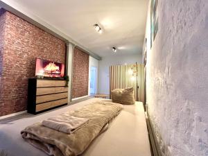 a bedroom with a bed and a brick wall at Industrial feeling in a quiet location in Leipzig