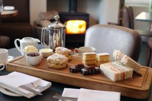 a wooden tray with pastries and sweets on a table at The Crown Hotel in Wells next the Sea