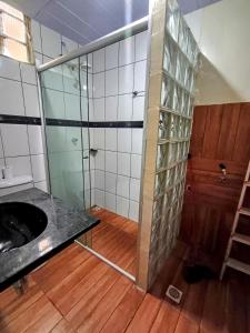 ein Badezimmer mit Waschbecken und Glasdusche in der Unterkunft Apto inteiro 3 quartos, sendo duas suítes in Belém