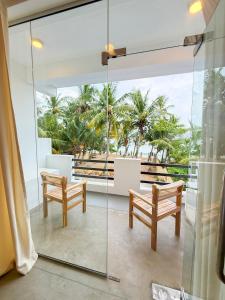 a room with two benches and a view of the ocean at OLA Tangalle in Tangalle