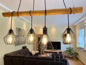a living room with a couch and four lights at Suite Am Radweg in Pittenbach