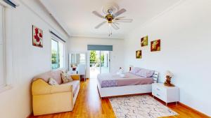 ein Schlafzimmer mit einem Bett, einem Sofa und einem Ventilator in der Unterkunft Villa Olivia in Lapithos