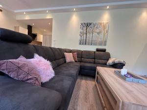 a living room with a brown couch and a wooden table at Suite Am Radweg in Pittenbach