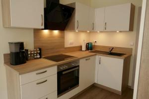 a kitchen with white cabinets and a counter top at Suite Am Radweg in Pittenbach +33 photos