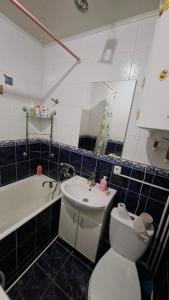 a bathroom with a toilet and a sink and a tub at Апартаменти біля Автовокзалу in Kryvyi Rih