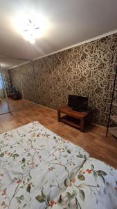 a bedroom with a bed and a tv in it at Апартаменти біля Автовокзалу in Kryvyi Rih