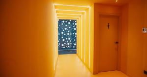 an orange hallway with a door with a window at Wostel The Comfort Hostel in Málaga