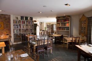 a restaurant with tables and chairs and books at The Crown Hotel in Wells next the Sea