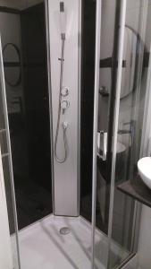 a shower with a glass door in a bathroom at Suite Blanche in Ostend