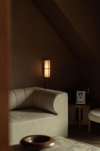 a living room with a couch and a lamp at Audo Boutique Hotel in Copenhagen