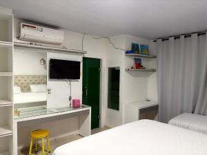 a bedroom with a bed and a desk with a television at Grande casa para COP30 perto do parque da cidade in Belém