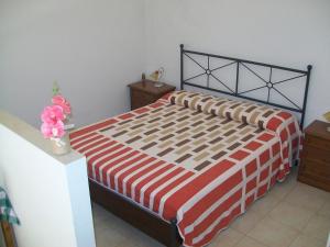 Dormitorio con cama con colcha de rayas rojas y blancas en Appartamento Mariana, en Matera