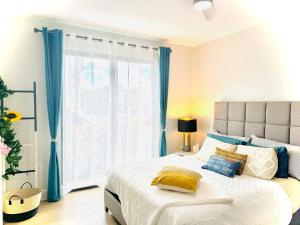 a bedroom with a large bed with blue curtains at Oceanfront Residency luxury 2B2B ,1-6 person ,terrasse, beach access garden pool in Old Man Bay +75 photos