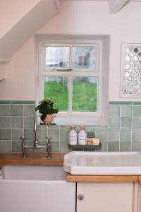 a kitchen with a sink and a window at Snowdrop Cottage in Jacobstowe