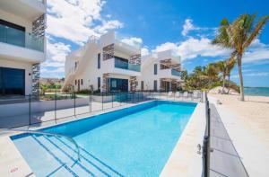 a villa with a swimming pool next to the beach at Oceanfront Residency luxury 2B2B ,1-6 person ,terrasse, beach access garden pool in Old Man Bay