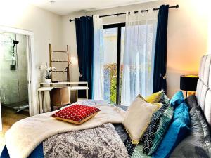 ein Bett mit Kissen darauf in einem Zimmer mit Fenster in der Unterkunft Oceanfront Residency luxury 2B2B ,1-6 person ,terrasse, beach access garden pool in Old Man Bay + 74 Fotos