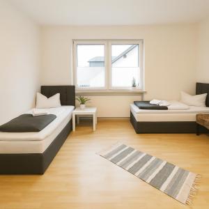 two beds in a room with a window and a rug at SUNNYHOME Monteurwohnungen und Apartments in Schwandorf in Schwandorf in Bayern