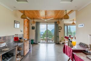 a kitchen with a view of a balcony at Yecha House - Mountain & Lake View Retreat, Bhimtal in Bhīm Tāl