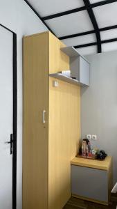 a kitchen with a wooden cabinet in a room at The Lakebox Menjer by Travelink in Garung